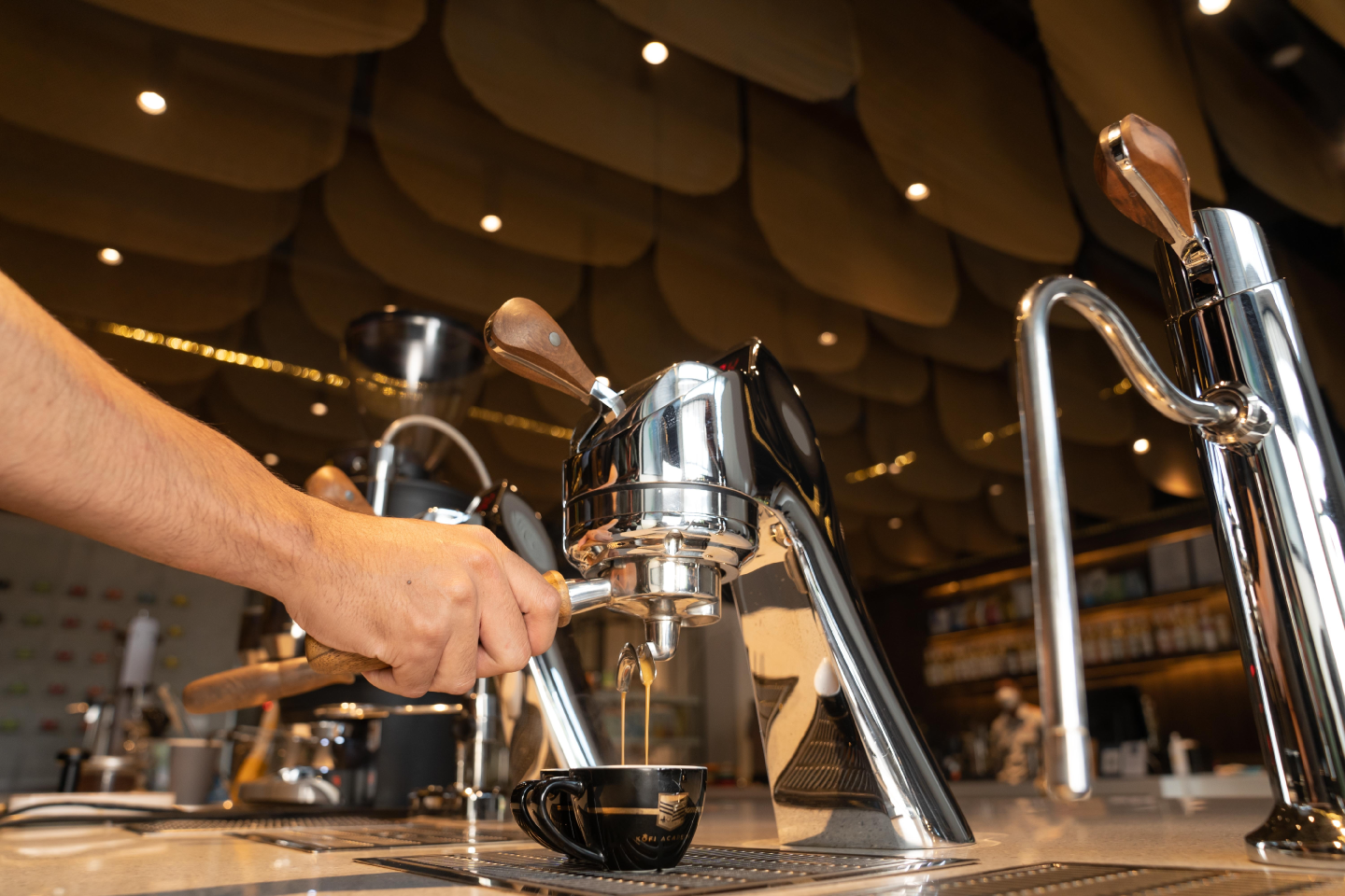 A barista preparing espresso at a café coffee machine
